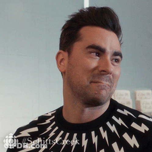 A Man Wearing A Black Sweater With Lightning Bolts On It Is Smiling GIF