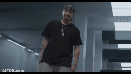 A Man Wearing A Black T-Shirt And A Bandana Has The Letter B On His Arm GIF