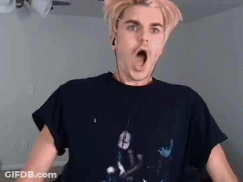 A Man Wearing A Black T-Shirt And Earphones Is Making A Funny Face . GIF