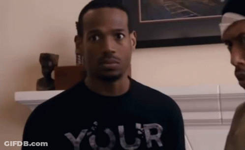 A Man Wearing A Black T-Shirt That Says Your Is Standing Next To Another Man . GIF