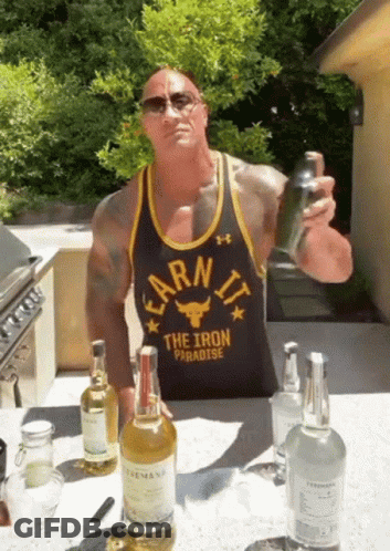 A Man Wearing A Black Tank Top That Says Earn It The Iron Paradise GIF