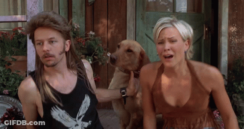 A Man Wearing A Black Tank Top With An Eagle On It Is Standing Next To A Woman And A Dog GIF