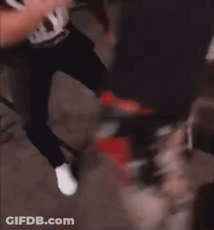 A Man Wearing A Black Tank Top With The Word Swat On It Is Being Held By Another Man . GIF