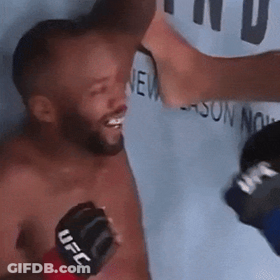 A Man Wearing A Black Ufc Glove Is Being Punched In The Face GIF