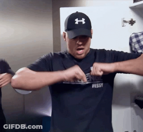 A Man Wearing A Black Under Armour Hat And A Black Shirt That Says Fessy GIF