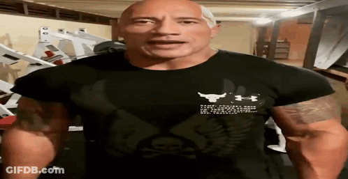 A Man Wearing A Black Under Armour Shirt Is Standing In A Gym GIF