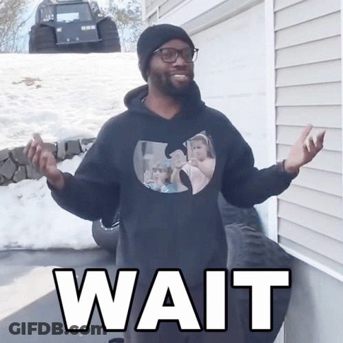 A Man Wearing A Black Wu Tang Sweatshirt Says Wait GIF