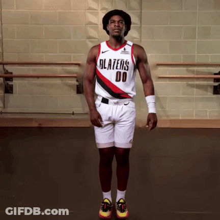 A Man Wearing A Blazers Jersey And Shorts Jumps In The Air GIF