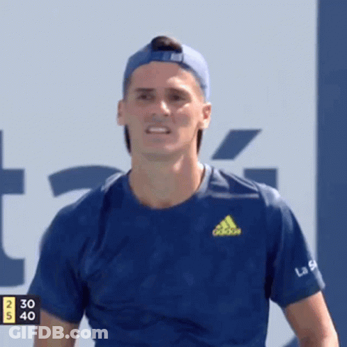 A Man Wearing A Blue Adidas Shirt And A Blue Hat Is Smiling . GIF