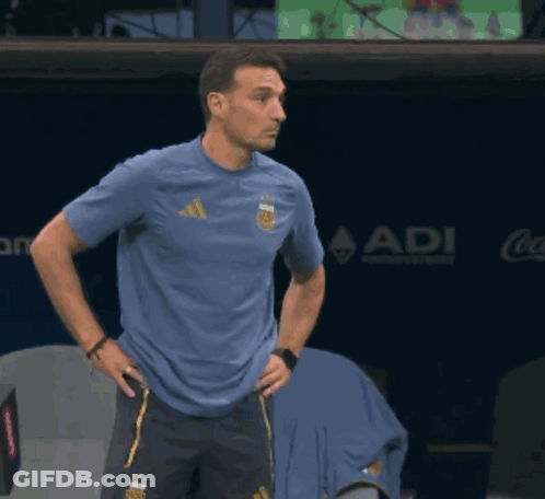 A Man Wearing A Blue Adidas Shirt Stands In Front Of A Coca Cola Sign GIF