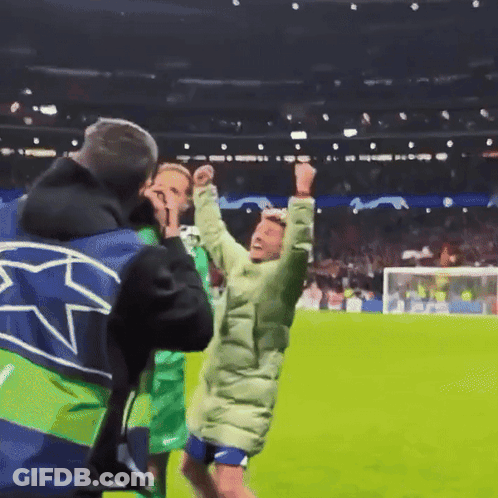 A Man Wearing A Blue And Green Jacket With A Star On It GIF