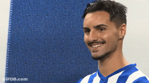 A Man Wearing A Blue And White Striped Shirt Smiles For The Camera GIF