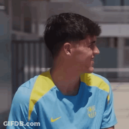A Man Wearing A Blue And Yellow Nike Shirt Looks To The Side GIF