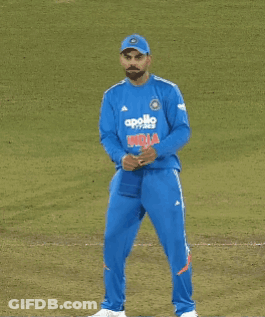 A Man Wearing A Blue Apollo Shirt Stands On A Field GIF