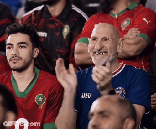 A Man Wearing A Blue Baeta Jersey Applauds In A Crowd GIF