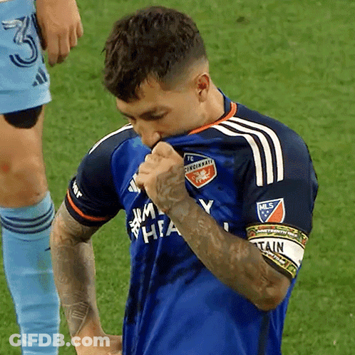 A Man Wearing A Blue Cincinnati Fc Jersey Holds His Shirt Up To His Face GIF