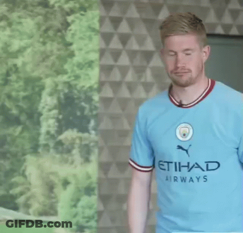 A Man Wearing A Blue Etihad Airways Shirt Stands In Front Of A Wall GIF