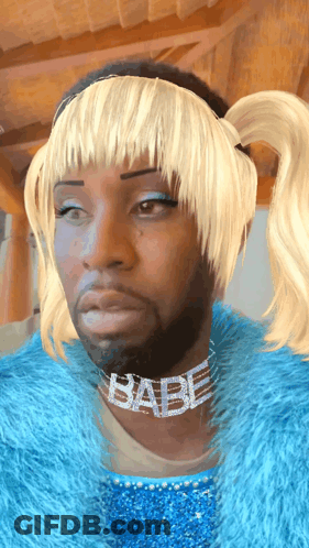 A Man Wearing A Blue Fur Coat And A Babe Necklace GIF