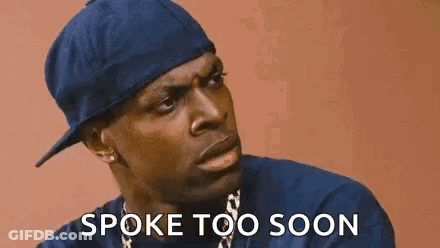 A Man Wearing A Blue Hat And A Necklace Is Talking To Someone And Says `` Spoke Too Soon '' . GIF