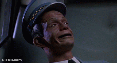 A Man Wearing A Blue Hat And A Suit Is Being Hit By A Bullet GIF