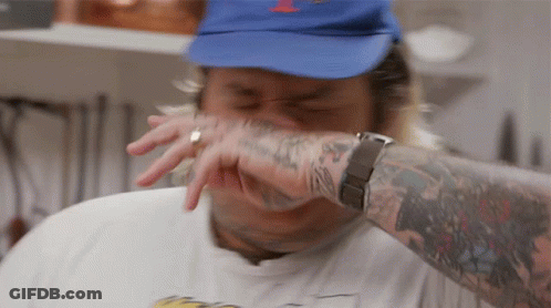 A Man Wearing A Blue Hat And A White Shirt Has A Tattoo On His Arm GIF