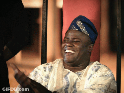 A Man Wearing A Blue Hat And A White Shirt Laughs With His Eyes Closed GIF