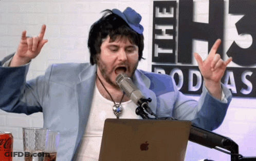 A Man Wearing A Blue Hat Is Singing Into A Microphone In Front Of A Coca Cola Can GIF