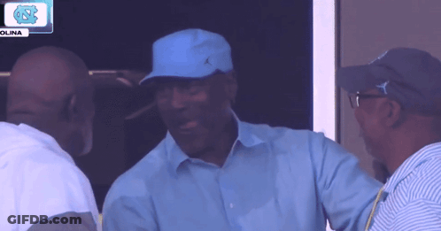 A Man Wearing A Blue Hat Is Talking To Another Man In Front Of A Sign That Says Olina GIF