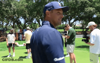 A Man Wearing A Blue Hat That Says New York Is Standing On A Golf Course GIF