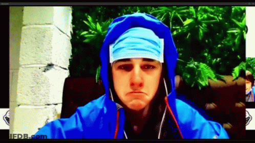 A Man Wearing A Blue Hooded Jacket And A Bandana On His Head GIF