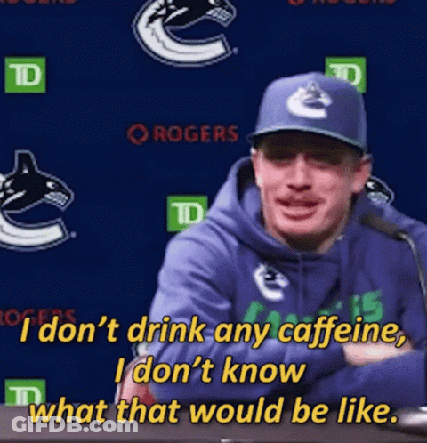 A Man Wearing A Blue Hoodie And A Blue Hat Is Talking Into A Microphone GIF