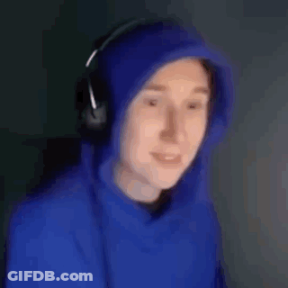 A Man Wearing A Blue Hoodie And Headphones Is Smiling And Looking At The Camera . GIF