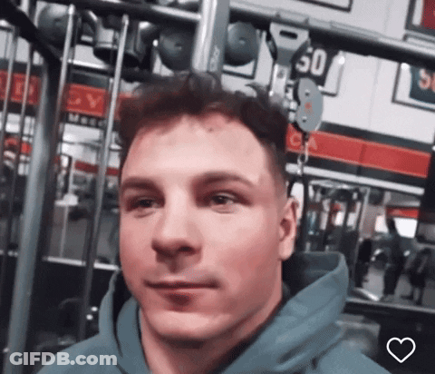 A Man Wearing A Blue Hoodie Is In A Gym With A Sign That Says 50 On It GIF