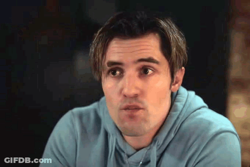 A Man Wearing A Blue Hoodie Is Making A Funny Face . GIF