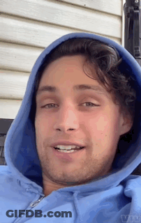 A Man Wearing A Blue Hoodie Is Smiling For The Camera GIF
