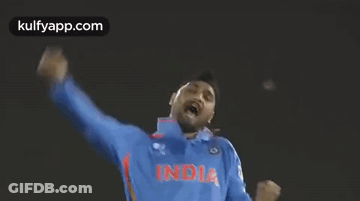 A Man Wearing A Blue India Jersey Is Raising His Arms In The Air GIF