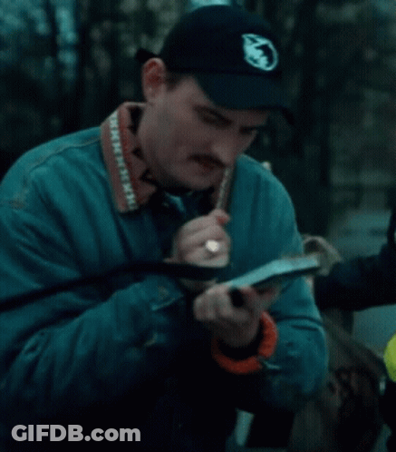 A Man Wearing A Blue Jacket And A Black Hat Has A Camera Strap That Says Minnesota On It GIF