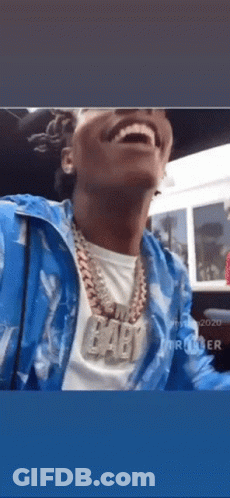 A Man Wearing A Blue Jacket And A Necklace With The Word Baby On It . GIF