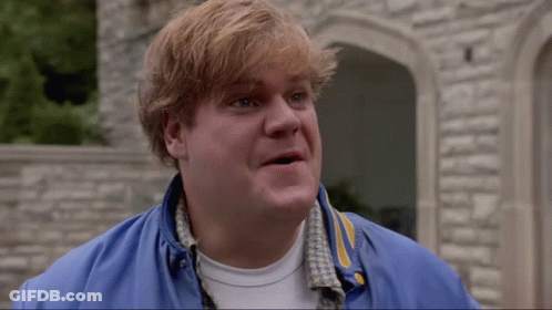 A Man Wearing A Blue Jacket And A White Shirt Is Standing In Front Of A Stone Wall GIF