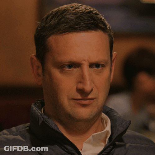 A Man Wearing A Blue Jacket And White Shirt Is Making A Funny Face GIF