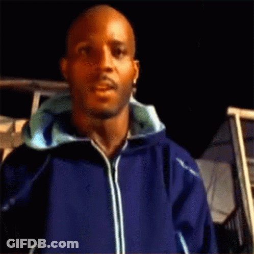 A Man Wearing A Blue Jacket Is Standing In Front Of A Building GIF