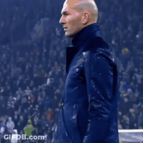 A Man Wearing A Blue Jacket Is Standing In Front Of A Crowd GIF