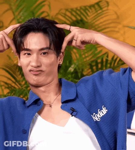 A Man Wearing A Blue Kodak Shirt Making A Face GIF