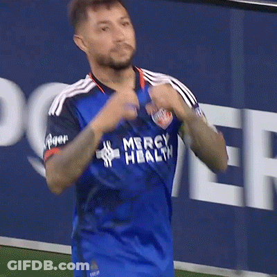 A Man Wearing A Blue Mercy Health Jersey Is Running On The Field GIF
