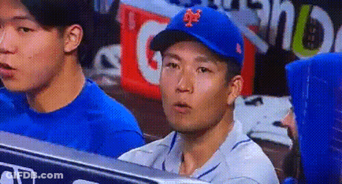 A Man Wearing A Blue Mets Hat Sits In A Dugout GIF