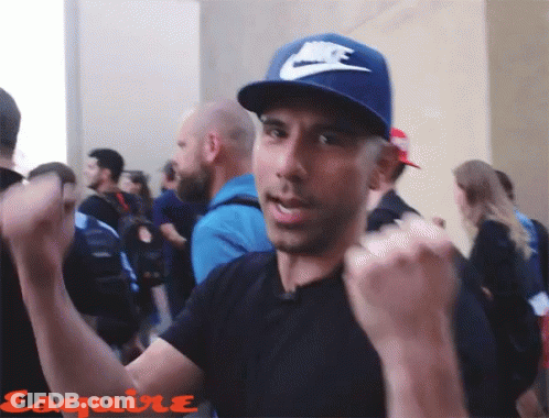 A Man Wearing A Blue Nike Hat Is Standing In A Crowd Of People GIF
