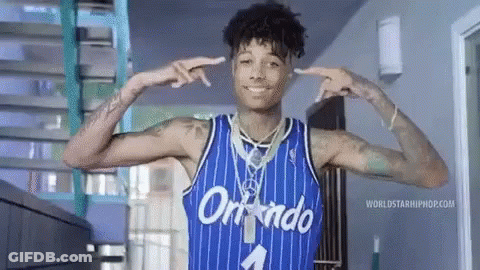 A Man Wearing A Blue Orlando Jersey Is Smiling And Pointing At His Ears . GIF