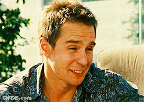 A Man Wearing A Blue Paisley Shirt Is Smiling GIF