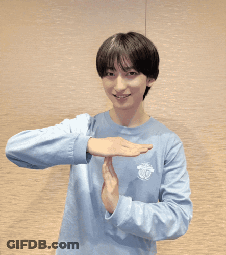 A Man Wearing A Blue Polo Shirt Is Making A Stop Sign GIF