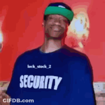 A Man Wearing A Blue Security Shirt Is Smiling GIF